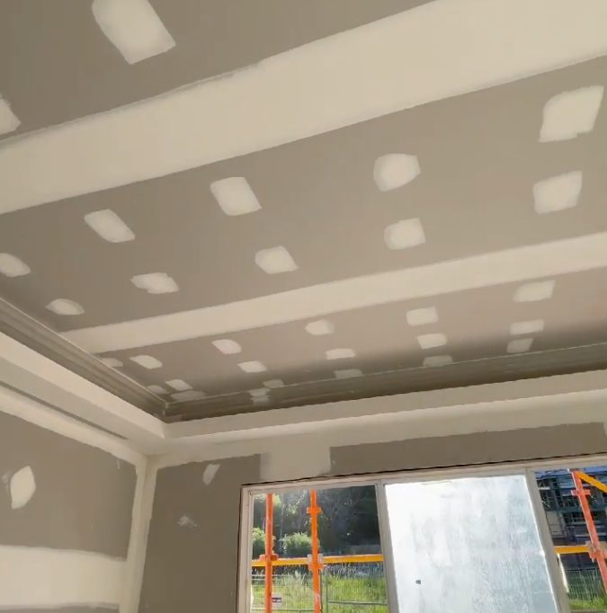 A bulkhead with a shadow gap and a light trough set into it, lined and coated ready for the painter.
