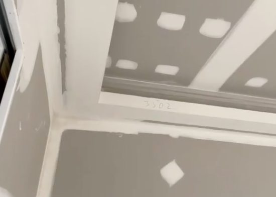 A square set junction between wall and ceiling, taped and set with no cornice, finished as a sharp clean line.