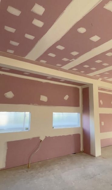 A room lined in fire rated board, walls and ceiling sheeted with the joints set flush.