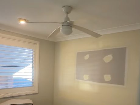 A patched section of wall in a lived in room, set and sanded flush and waiting on the painter.